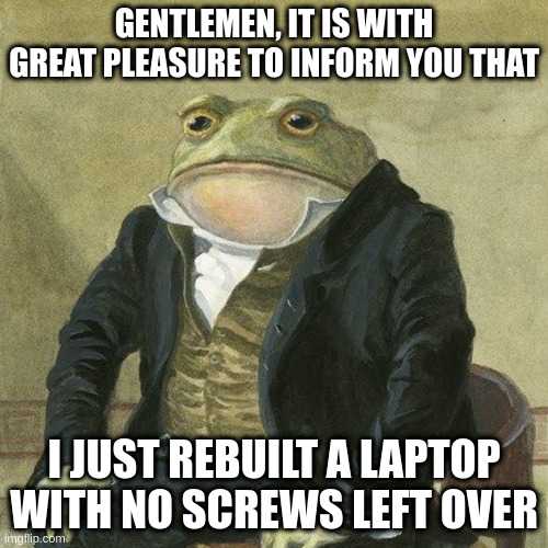 frog in a suit sitting at a table with a laptop