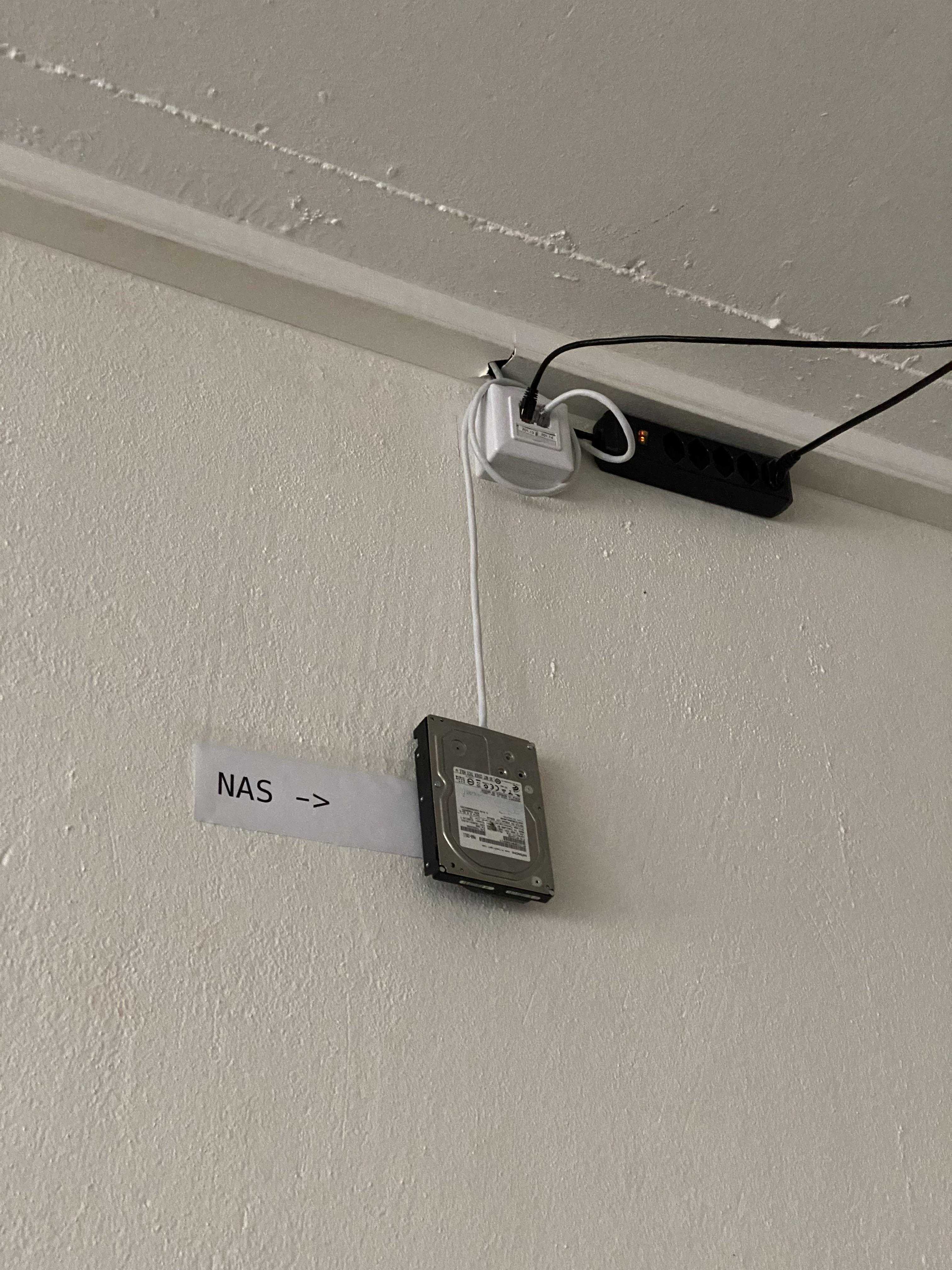 there is a small black device attached to a white wall