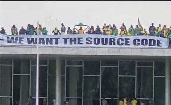 people are standing on the roof of a building with a banner