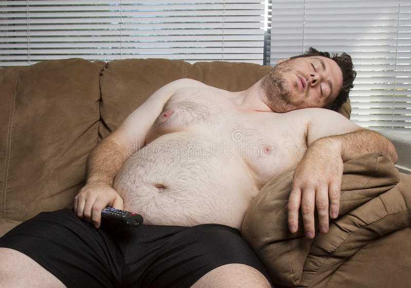 man laying on a couch with a remote control in his hand