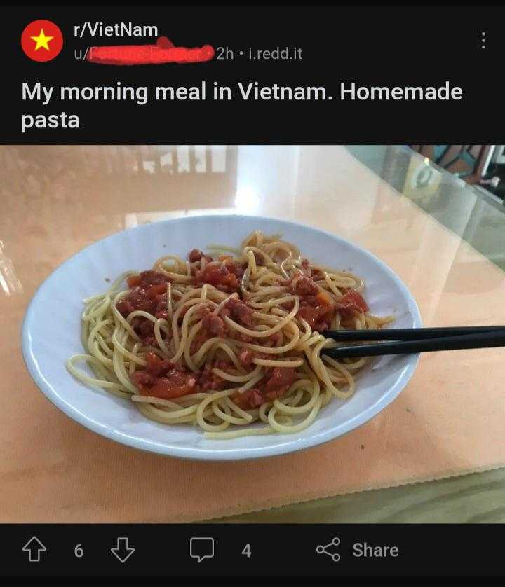 someone is eating a bowl of spaghetti with a fork