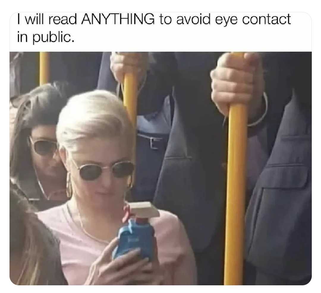 woman in pink shirt and sunglasses texting on cell phone while on bus