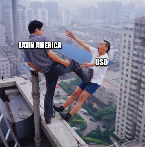 two men on a ledge with a city in the background