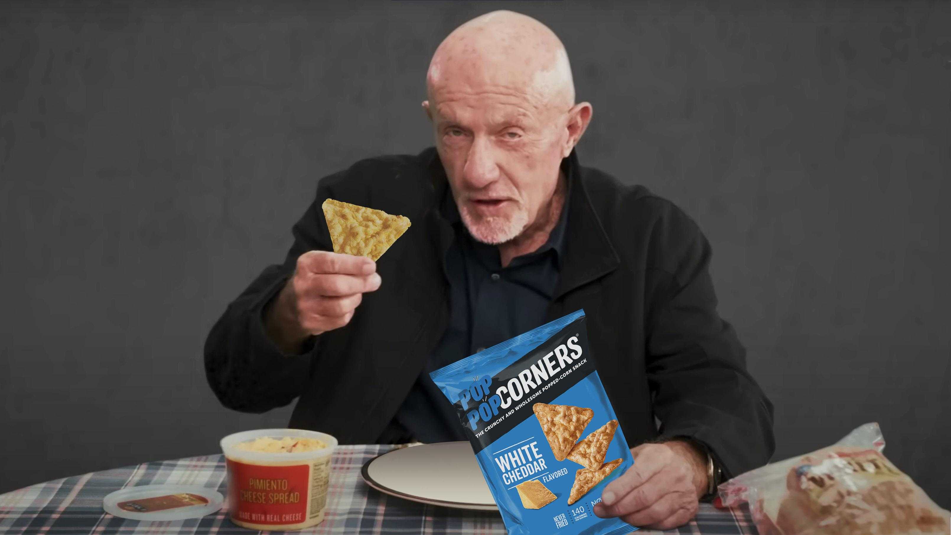 man eating a snack and holding a bag of chips