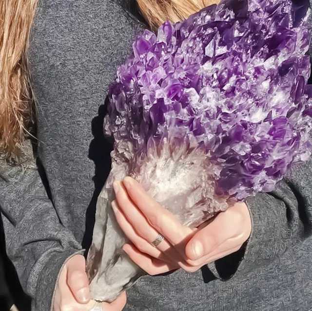 someone holding a bunch of purple crystals in their hands