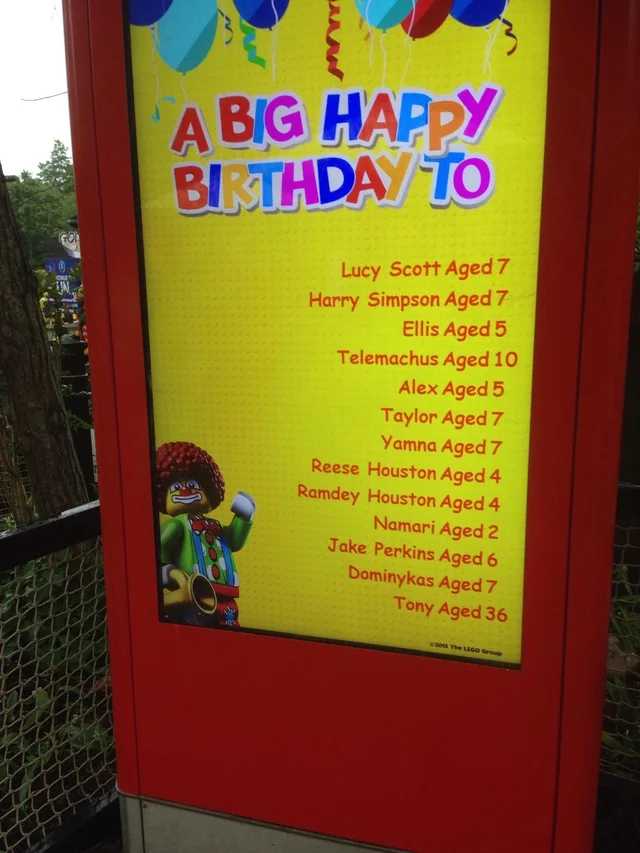 a close up of a sign with balloons and a clown on it