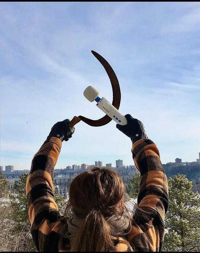 woman holding a large knife in the air with a city in the background