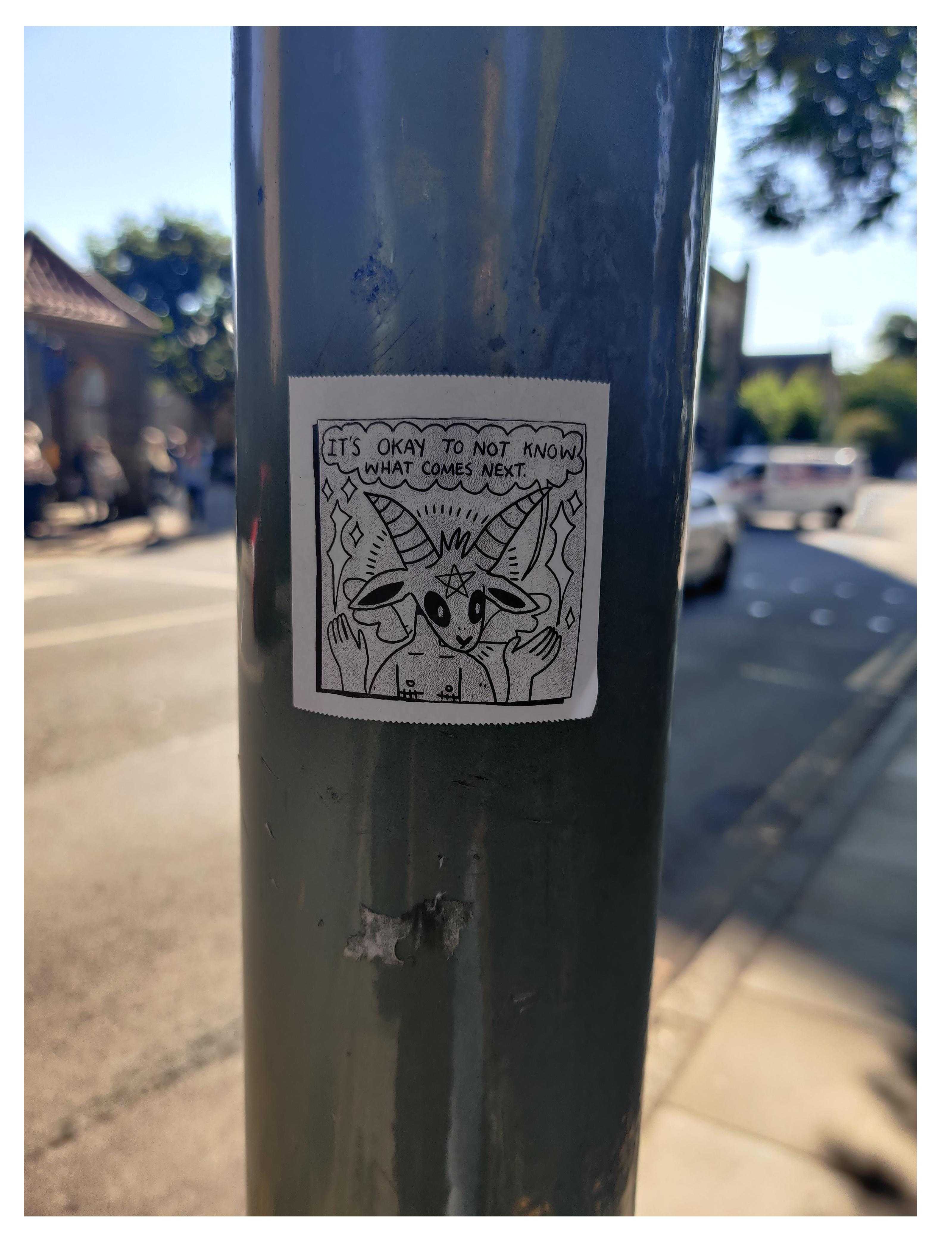 there is a sticker on a pole that has a drawing of a cat on it