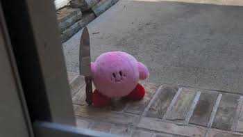 there is a pink stuffed animal sitting on the floor next to a knife