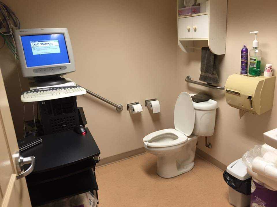 there is a computer on a desk in a bathroom