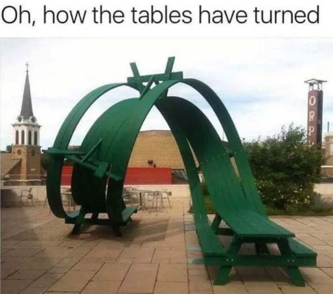 there is a green bench that is sitting on the ground