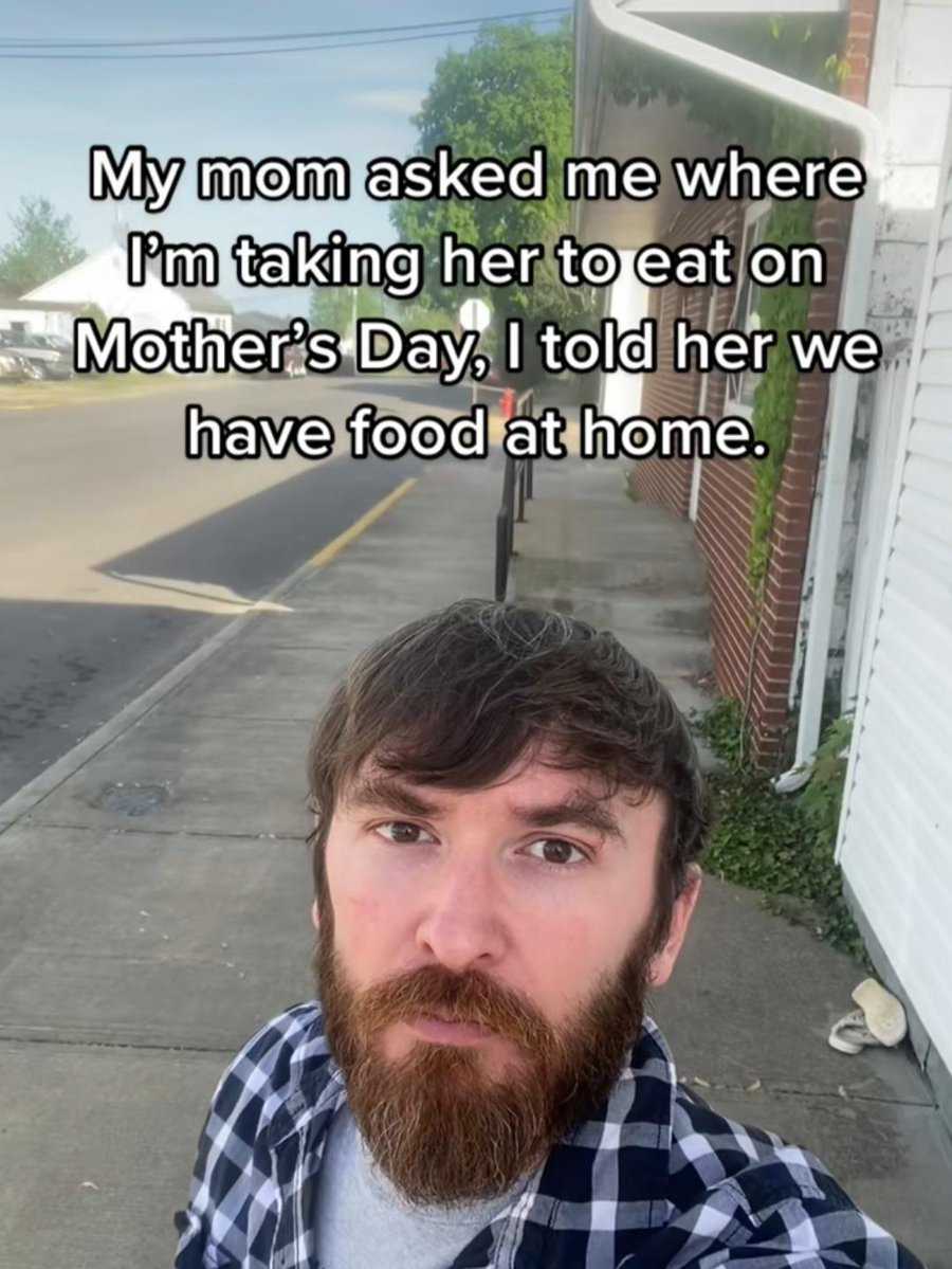 man with a beard and a plaid shirt on taking a selfie