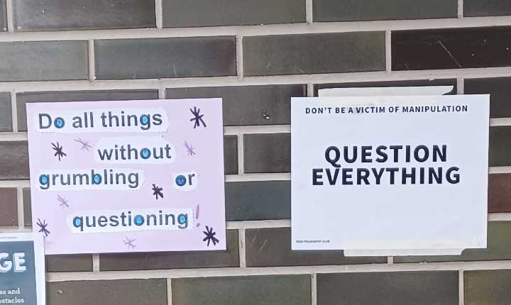 signs on a brick wall with a question and a question everything