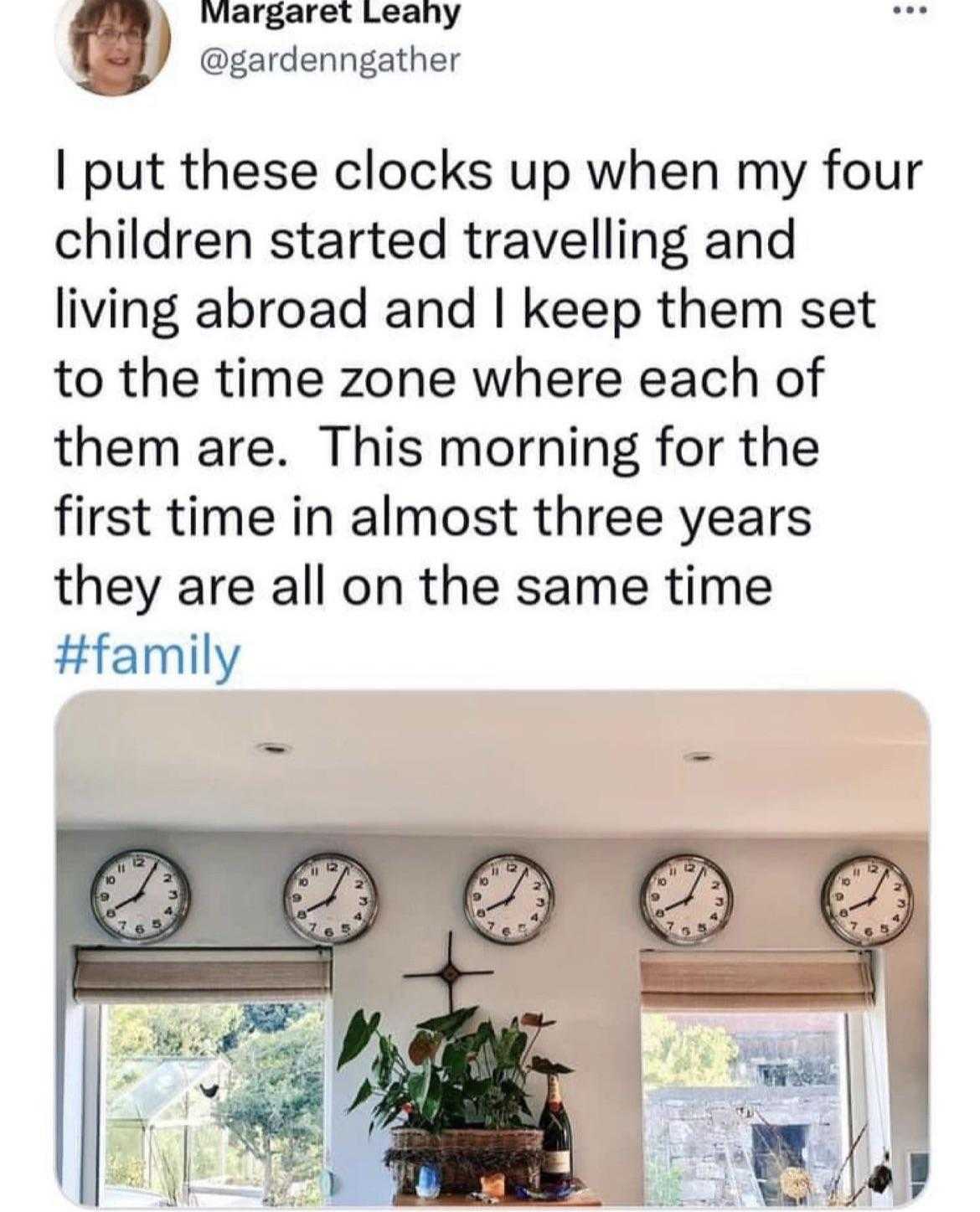 a close up of a person standing in a kitchen with clocks on the wall