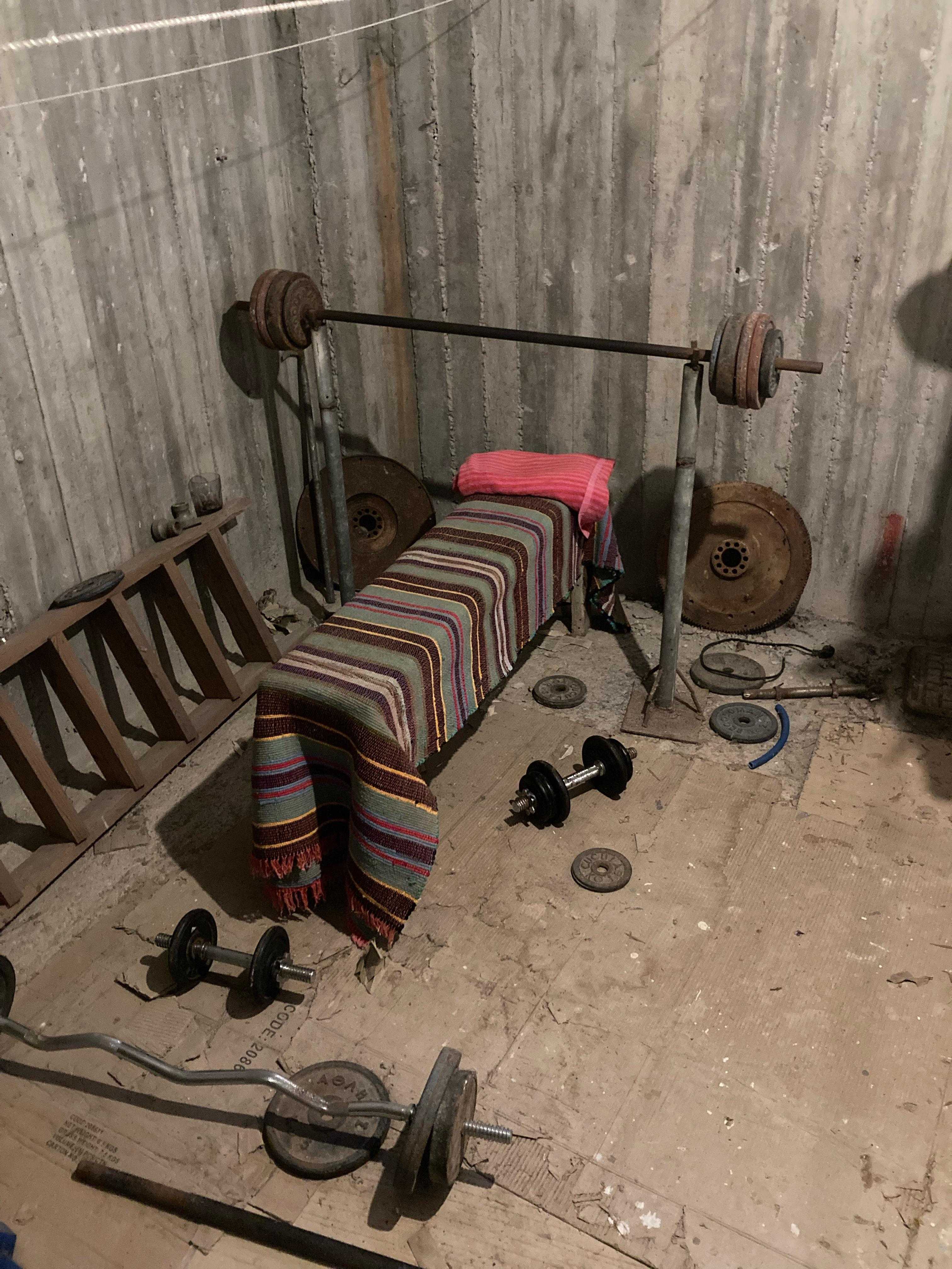 there is a bed with a striped blanket and a barbell