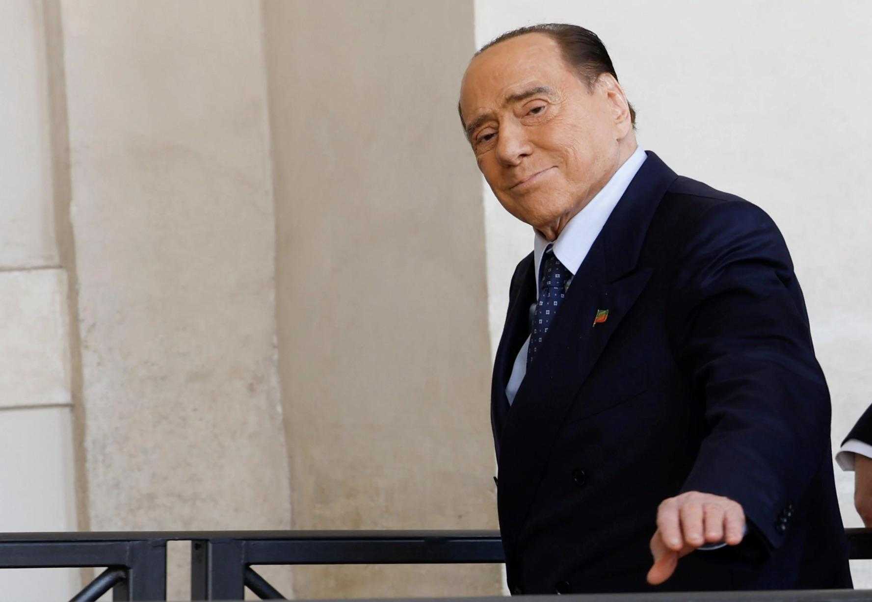 asian man in a suit and tie walking down a balcony