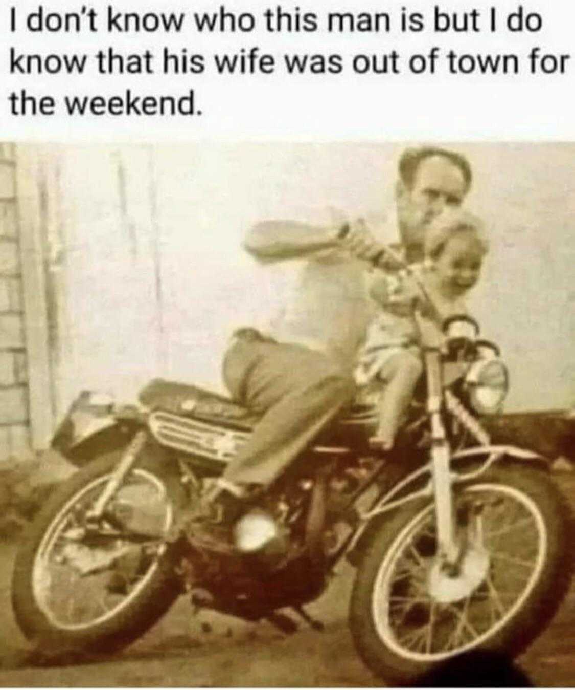 man sitting on a motorcycle with a child on the back