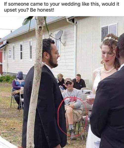 bride and groom standing in front of a house with a wedding ring