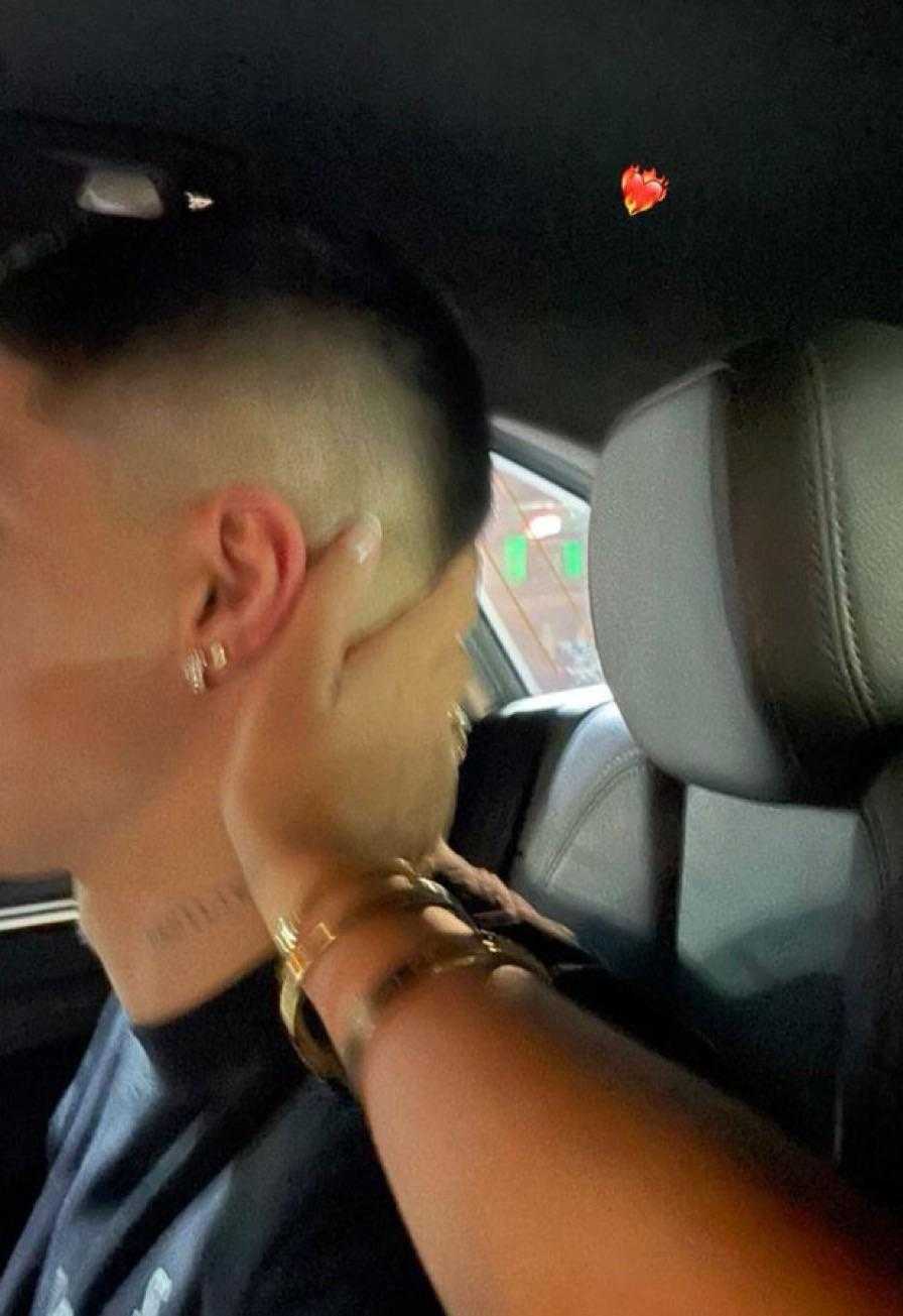 man with a shaved head and ear sitting in a car