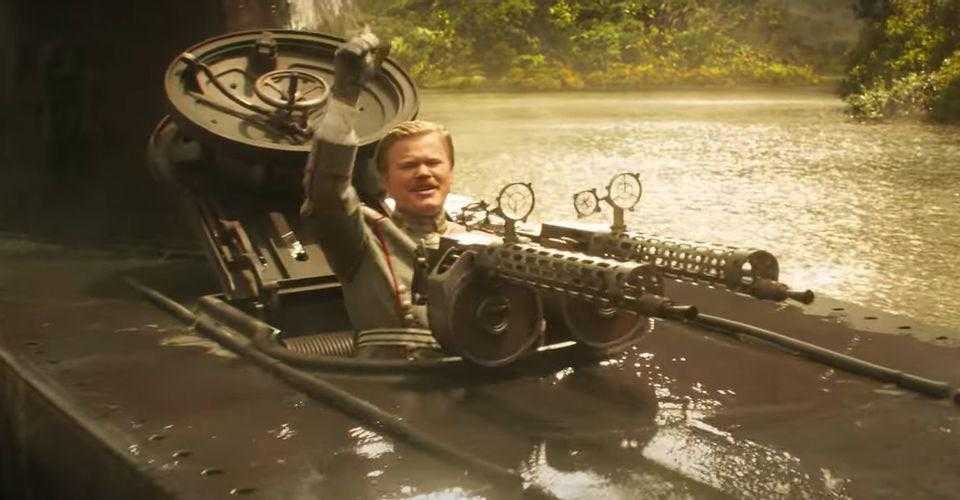 there is a man sitting in a boat with a machine gun