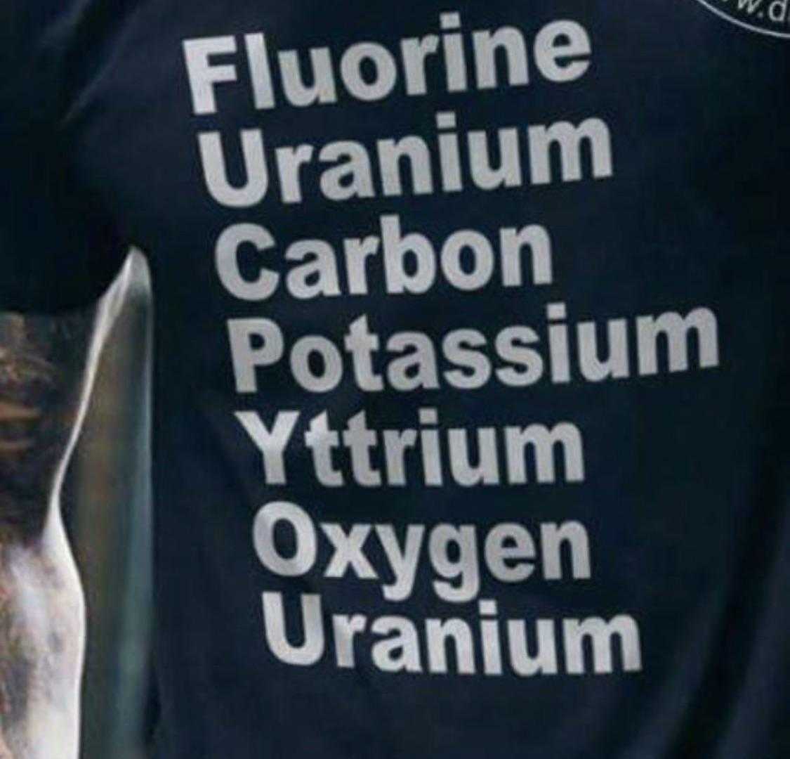 man with tattoos on his arm and a black shirt with the words fluorine uranium carbon potassiumium