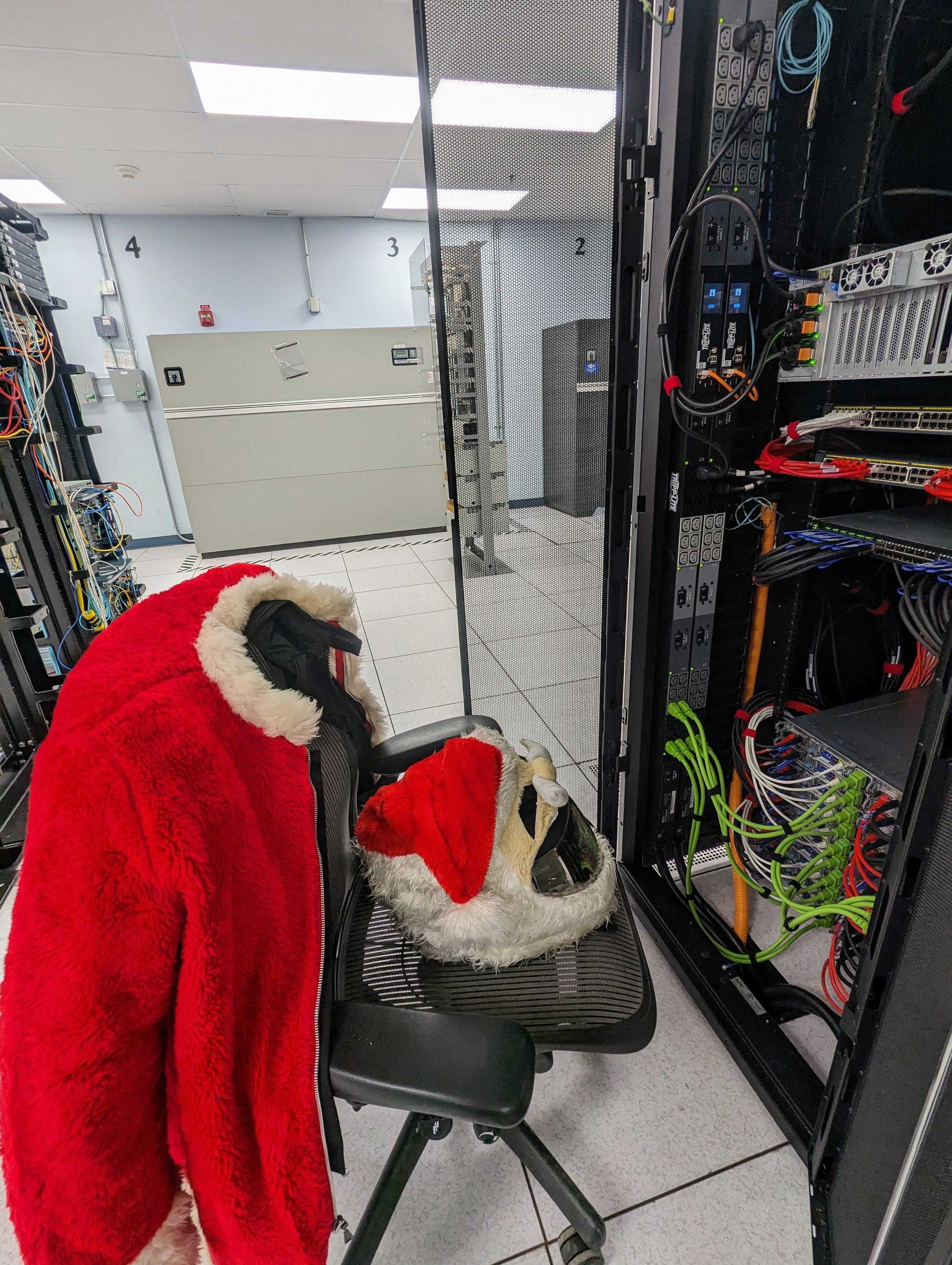 there is a stuffed animal in a santa hat sitting on a chair