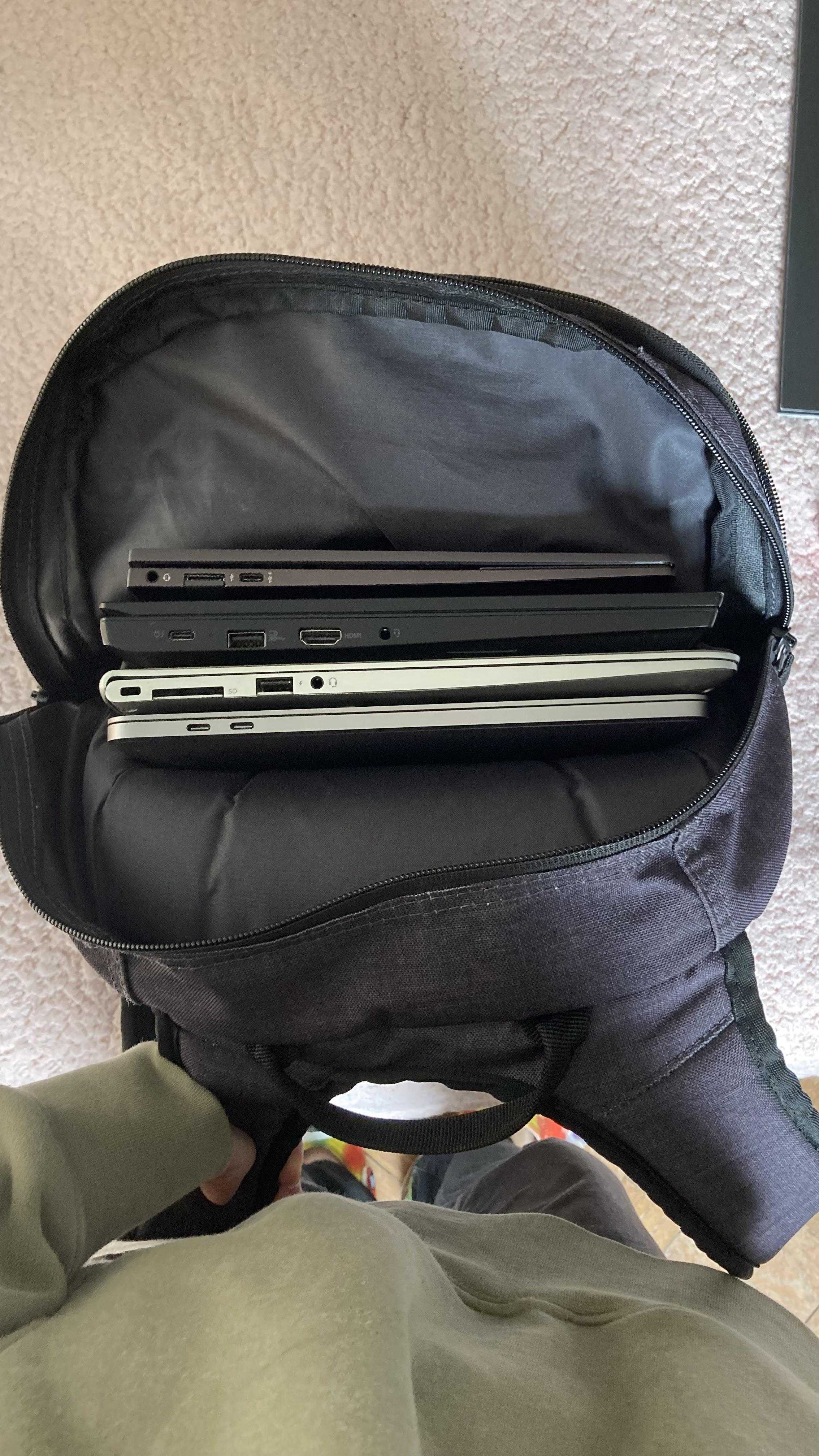 there is a laptop in a backpack with two laptops inside