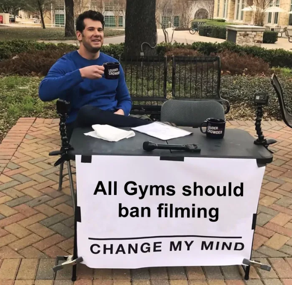 man sitting at a table with a sign that says, all gyms should ban filing change my mind