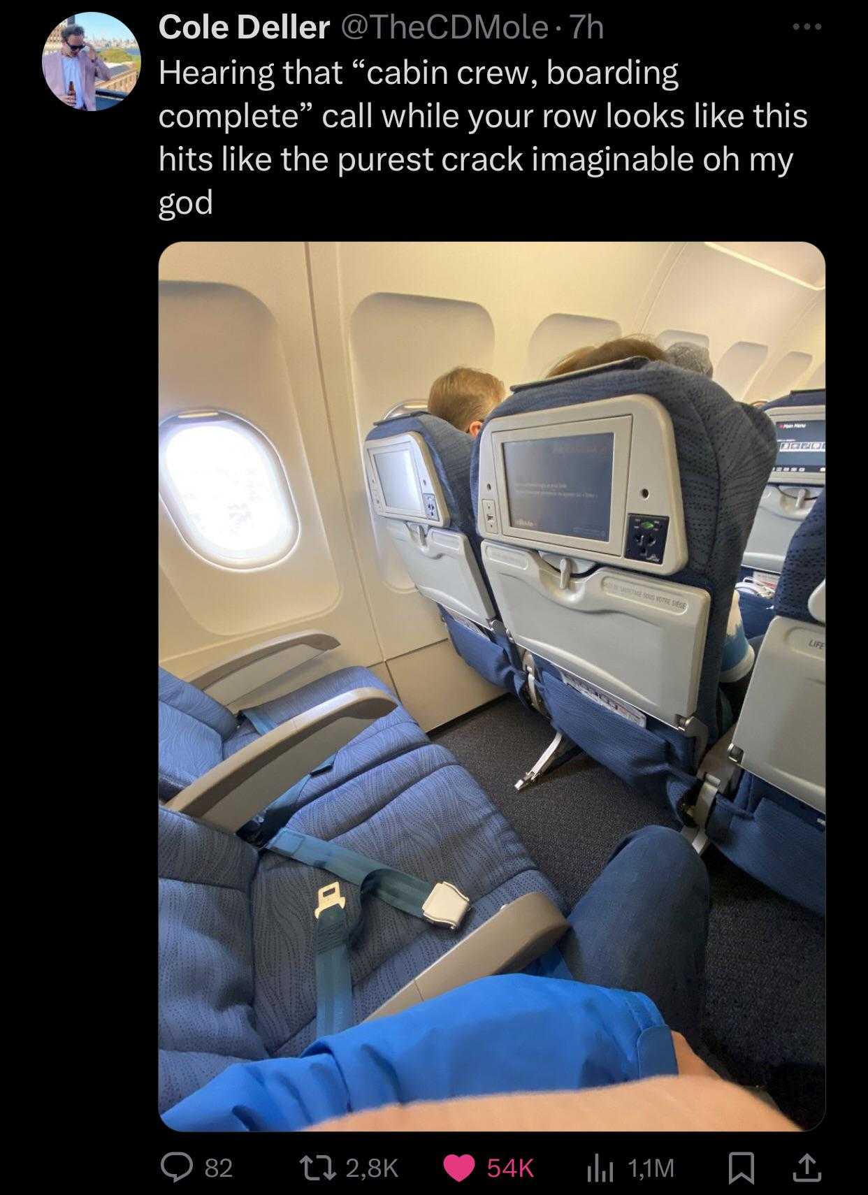 view of a person sitting in an airplane with their feet on the seat