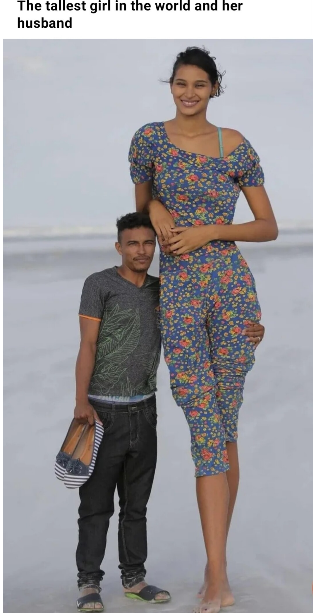 a woman standing next to a man on a beach