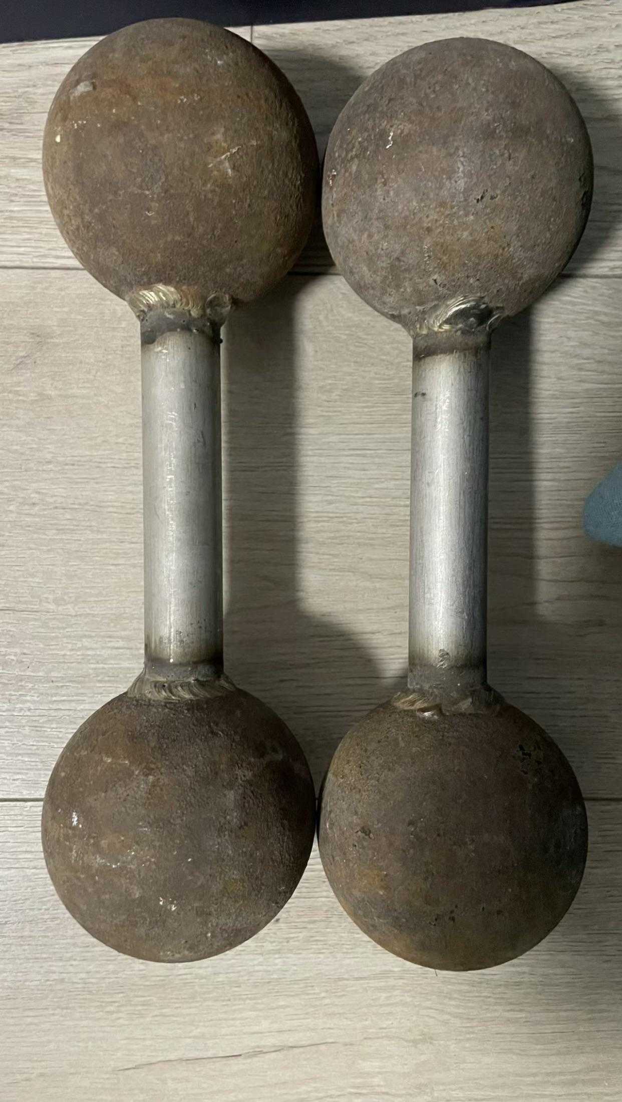 there are two old metal dumbs on a wooden table