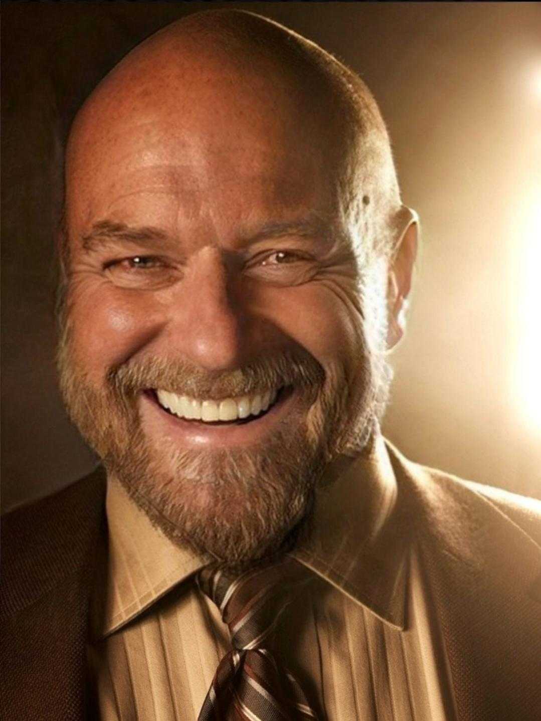 smiling man with beard and a suit jacket and tie