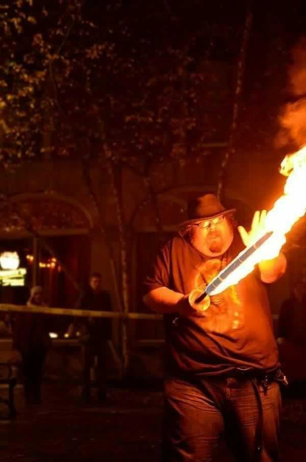 flames are lit up as a man holds a baseball bat