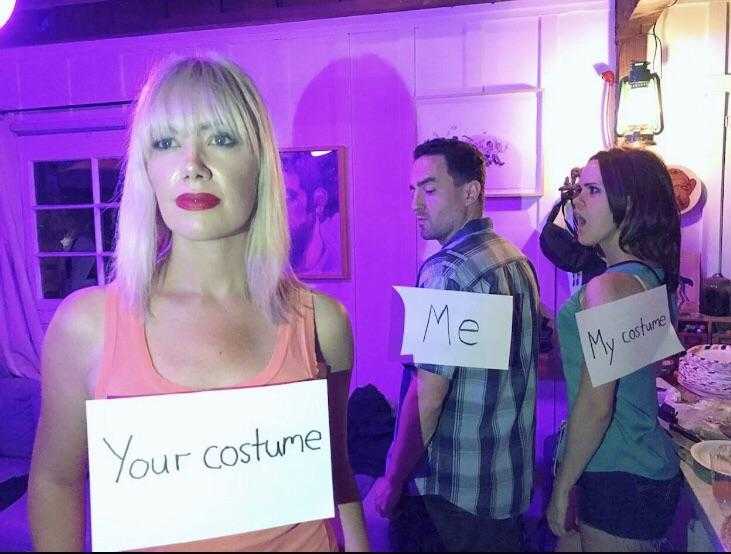 several people are standing in a room with signs that say your costume