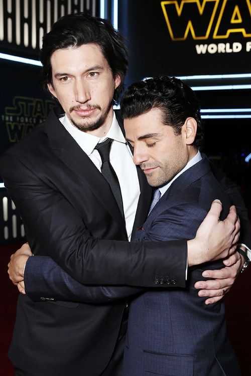 two men in suits hugging each other at a star wars premiere