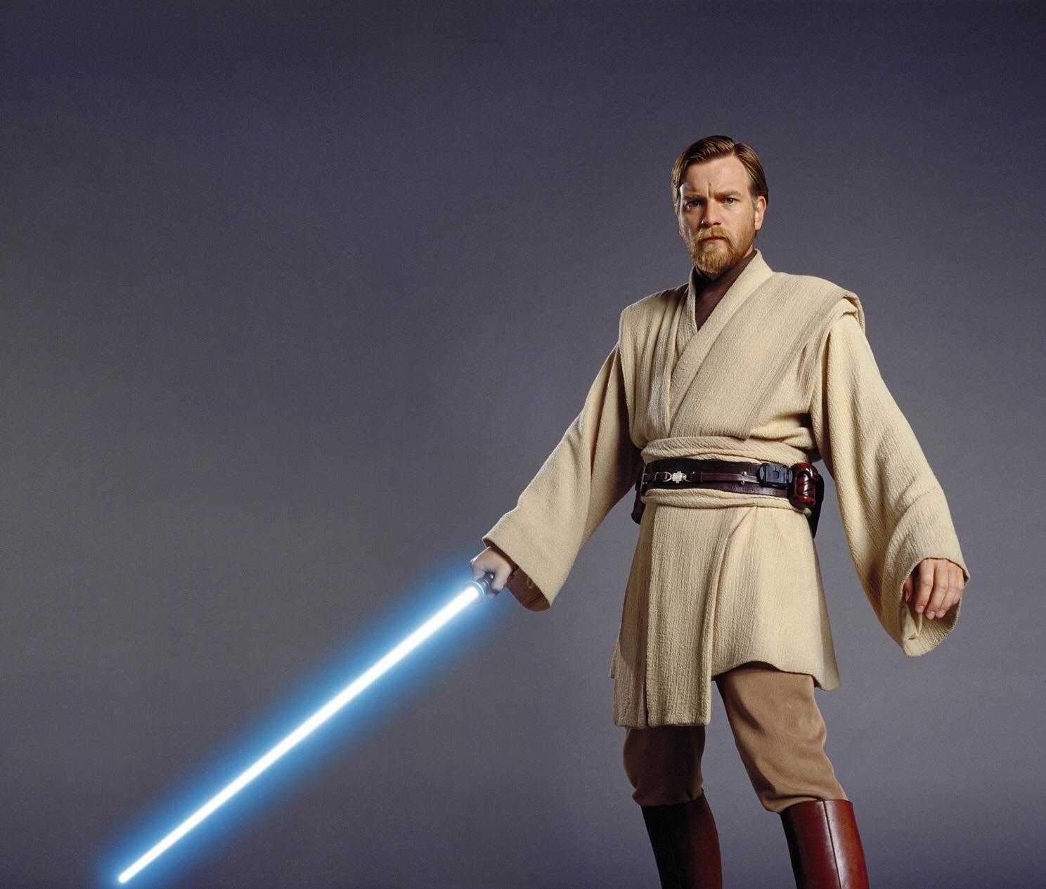 man in a robe with a light saber in his hand