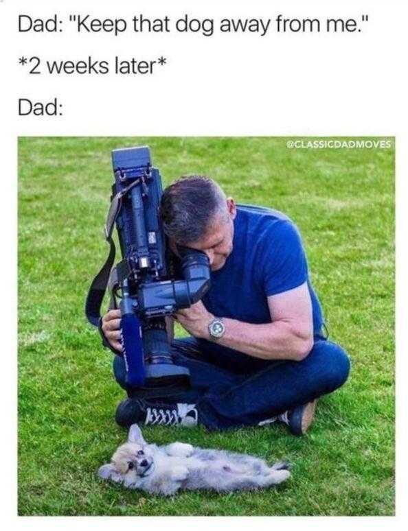 a man kneeling down with a camera and a dog laying on the ground