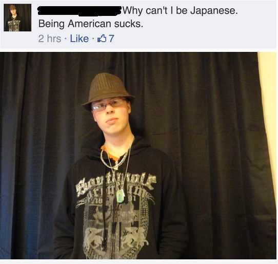 man in a black shirt and hat standing in front of a black curtain