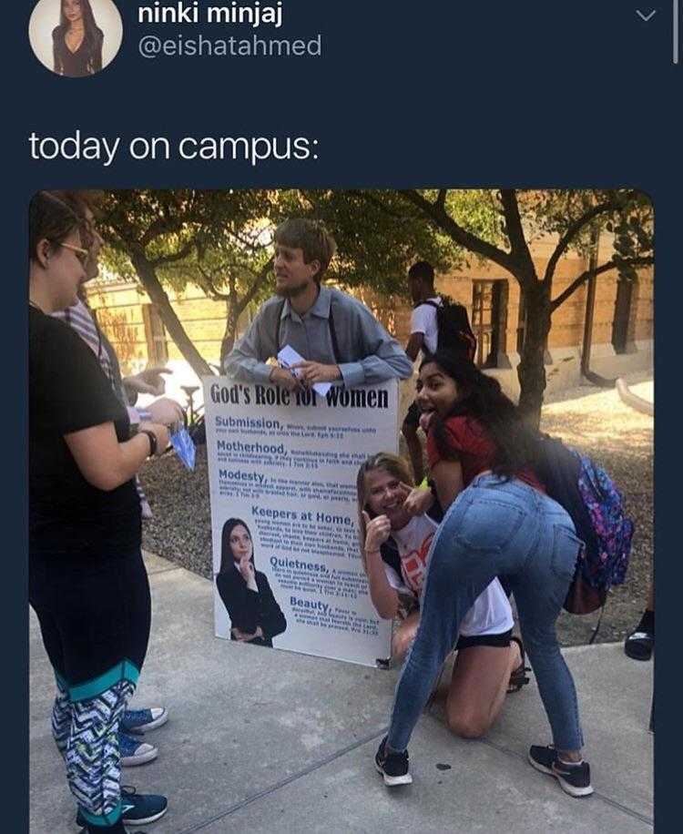 woman kneeling on the ground with a sign in front of her