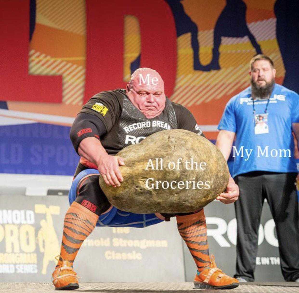 there is a man holding a large rock on a stage