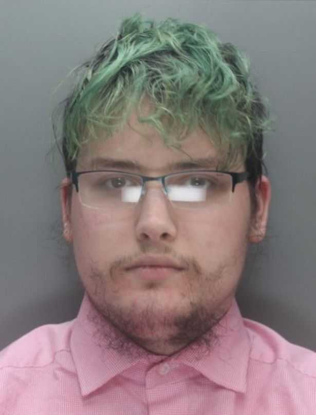 man with green hair and glasses wearing a pink shirt