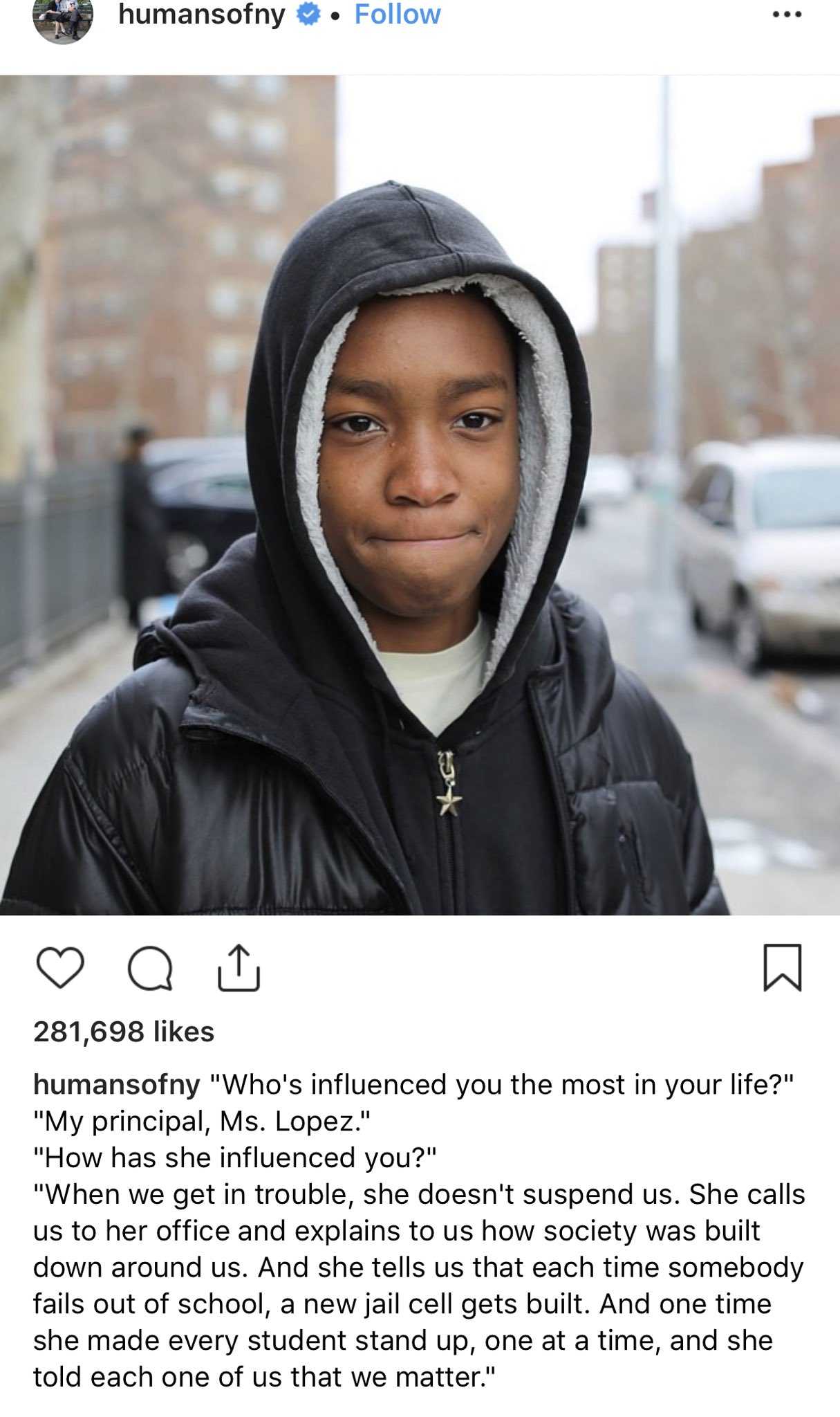 a close up of a person wearing a hoodie on a city street