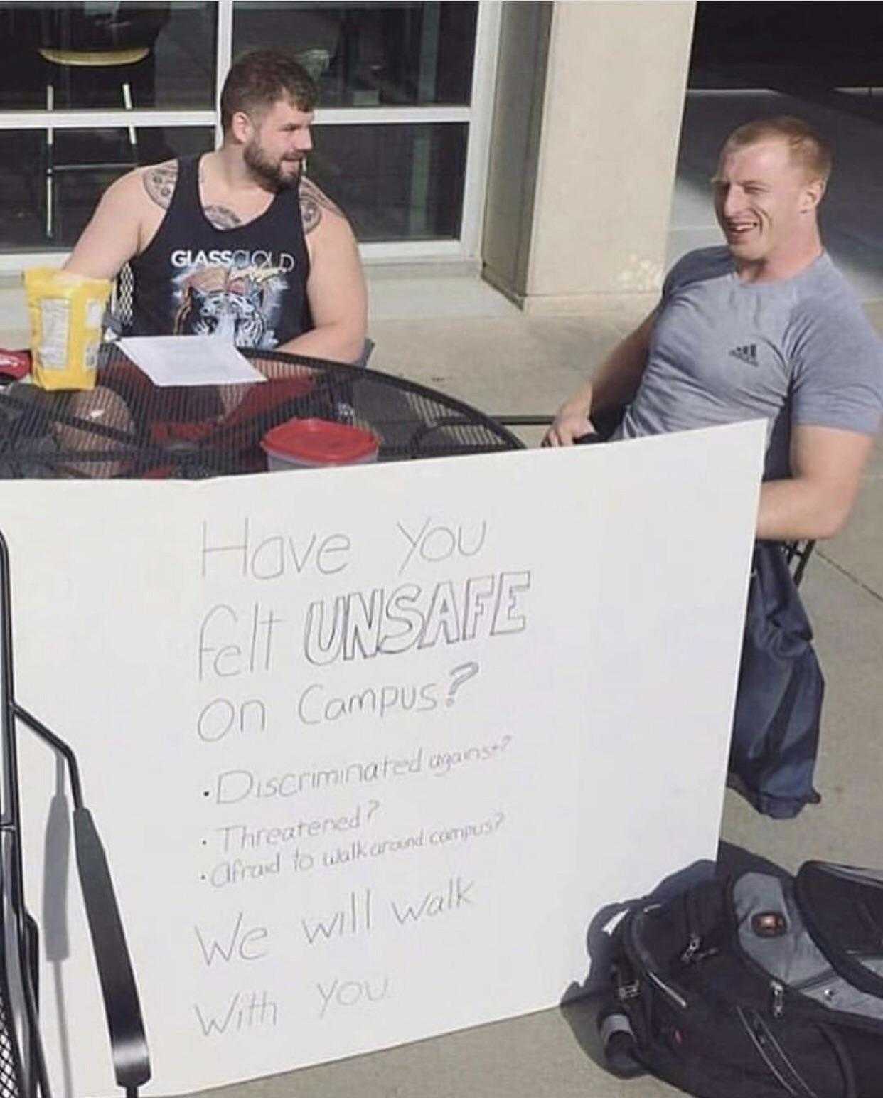 they are sitting at a table with a sign that says have you got insenstate on campus