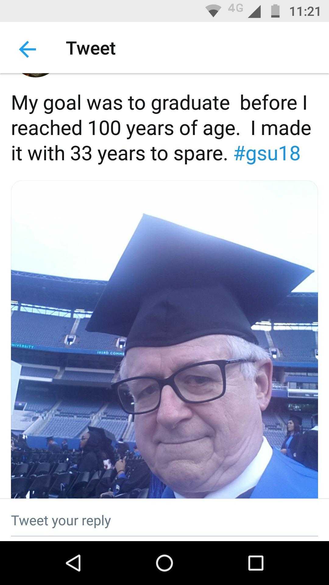 man in a graduation cap and glasses with a tweet