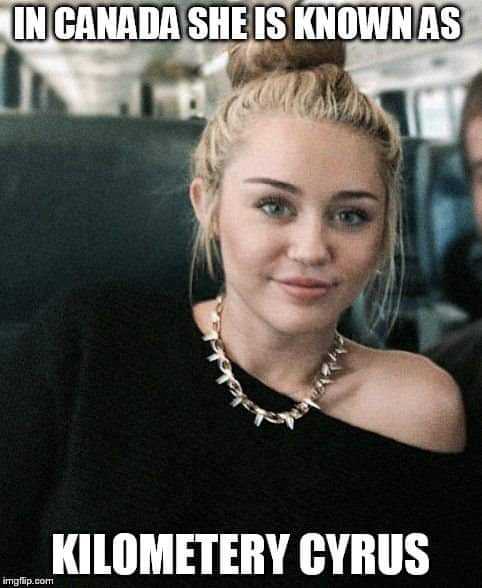 woman in a black dress sitting on a bus with a man in the background