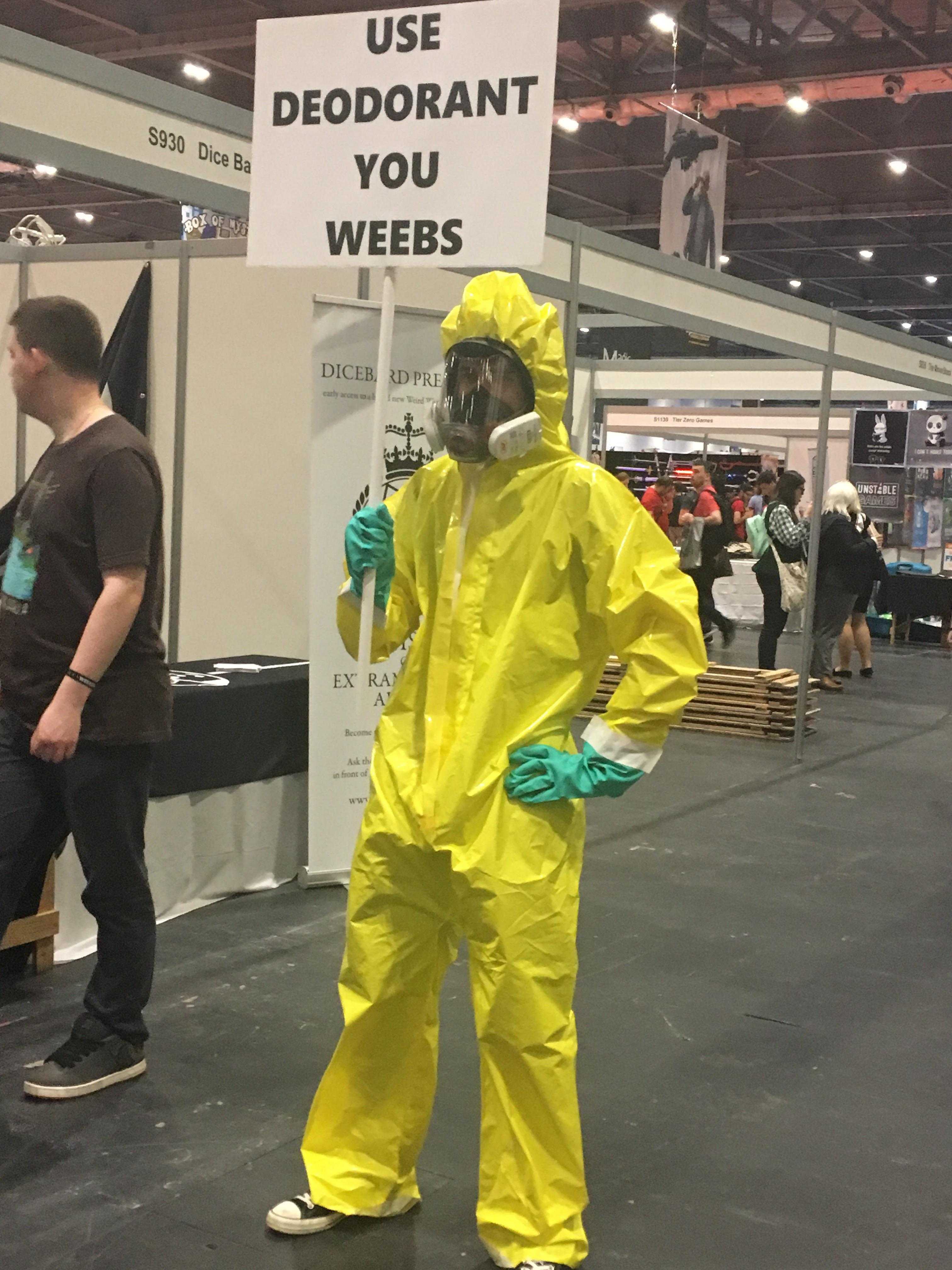 man in a yellow hazmat suit holding a sign