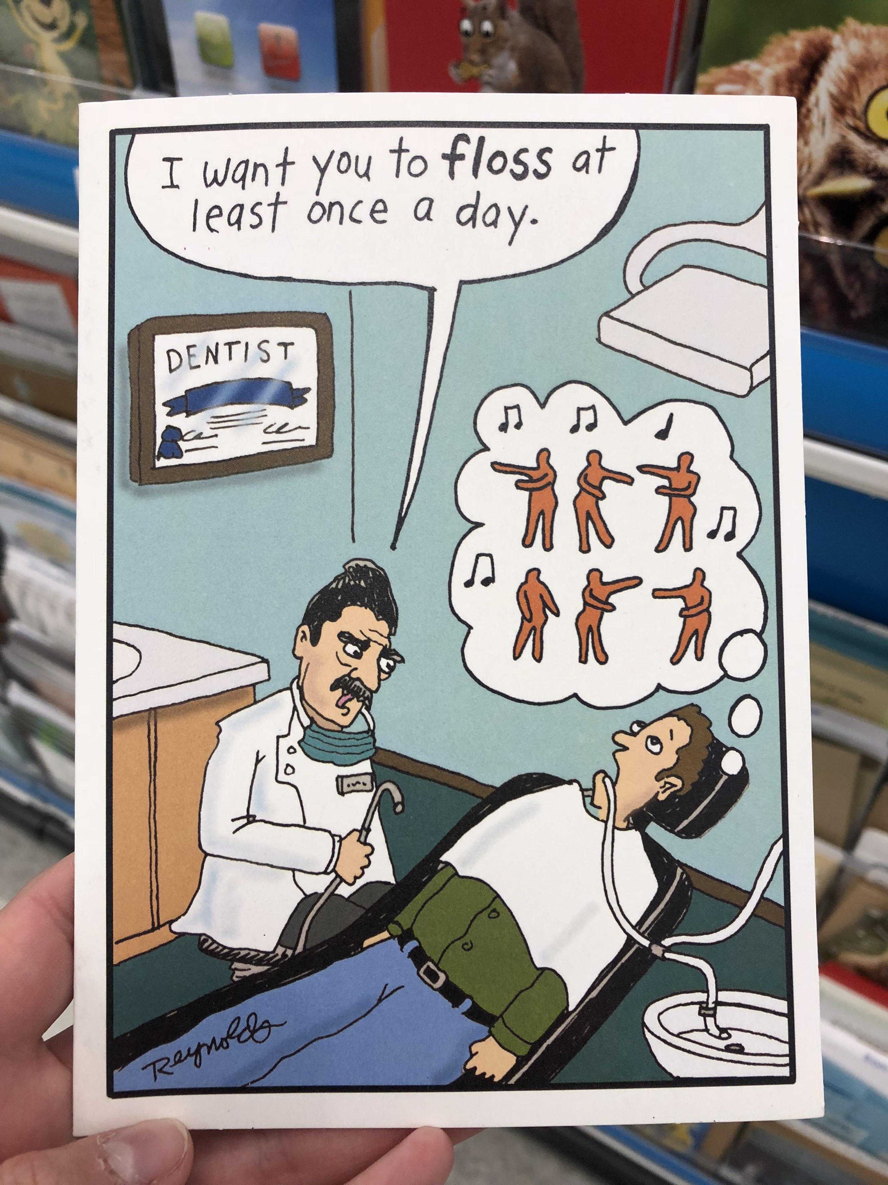 someone is holding a card with a cartoon of a dentist and a patient