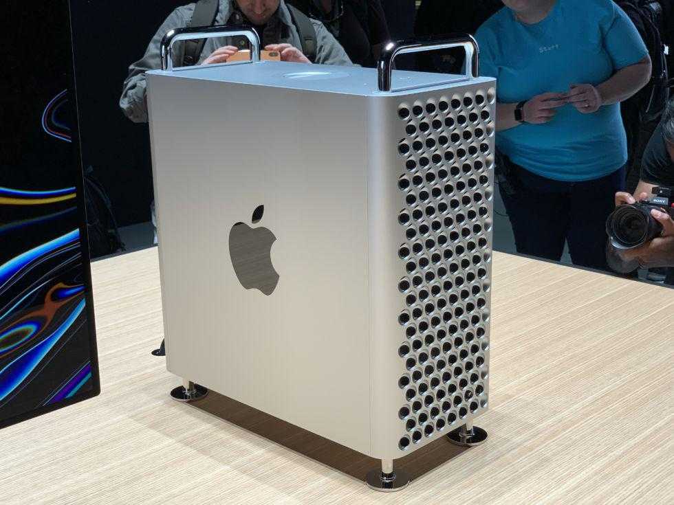 there is a man standing next to a mac pro on display