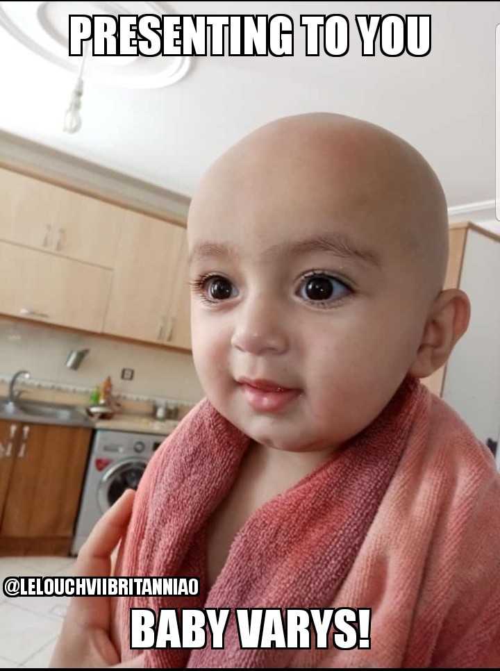 smiling baby wrapped in a pink towel in a kitchen