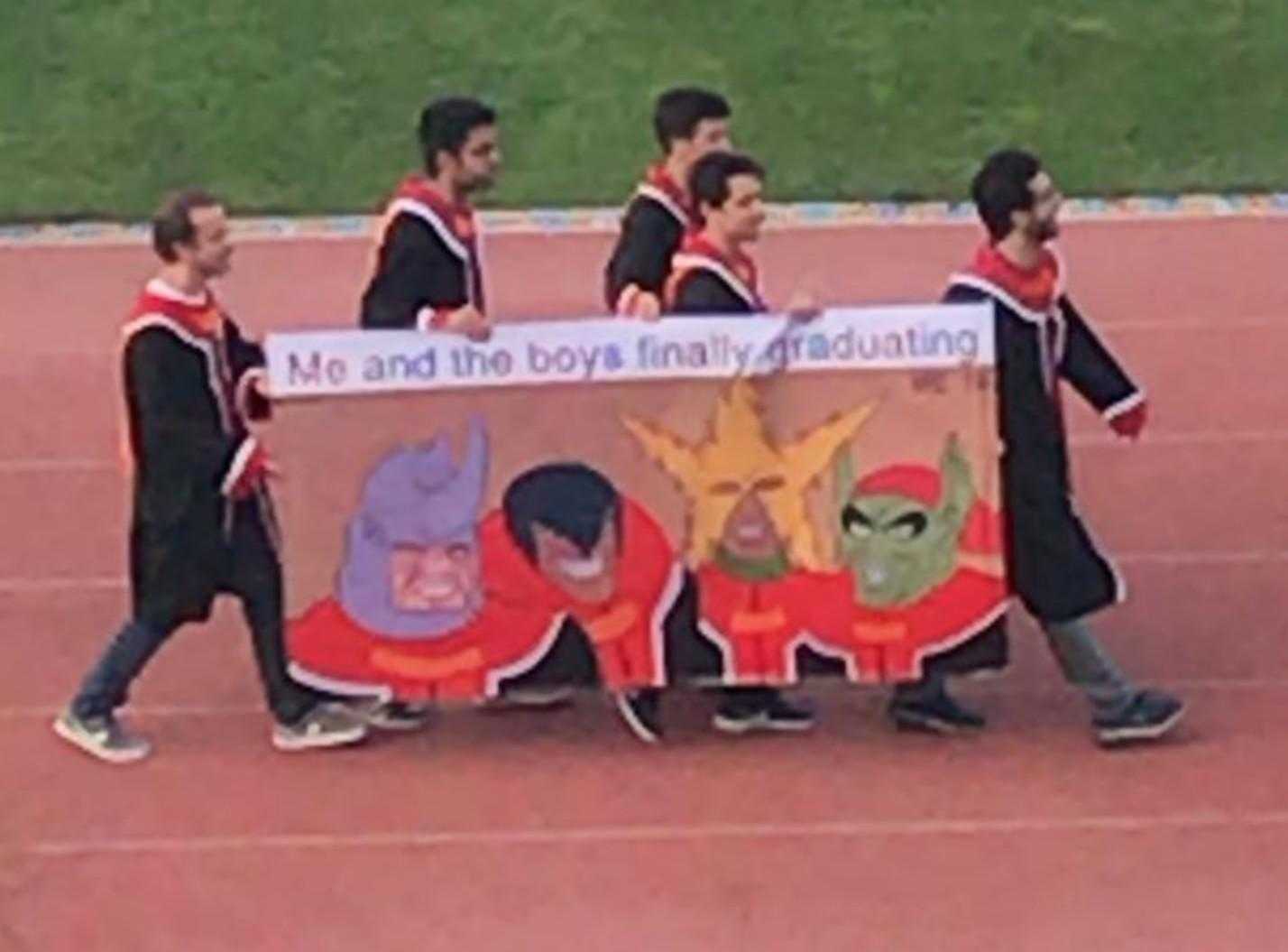 several children are walking on a track holding a banner